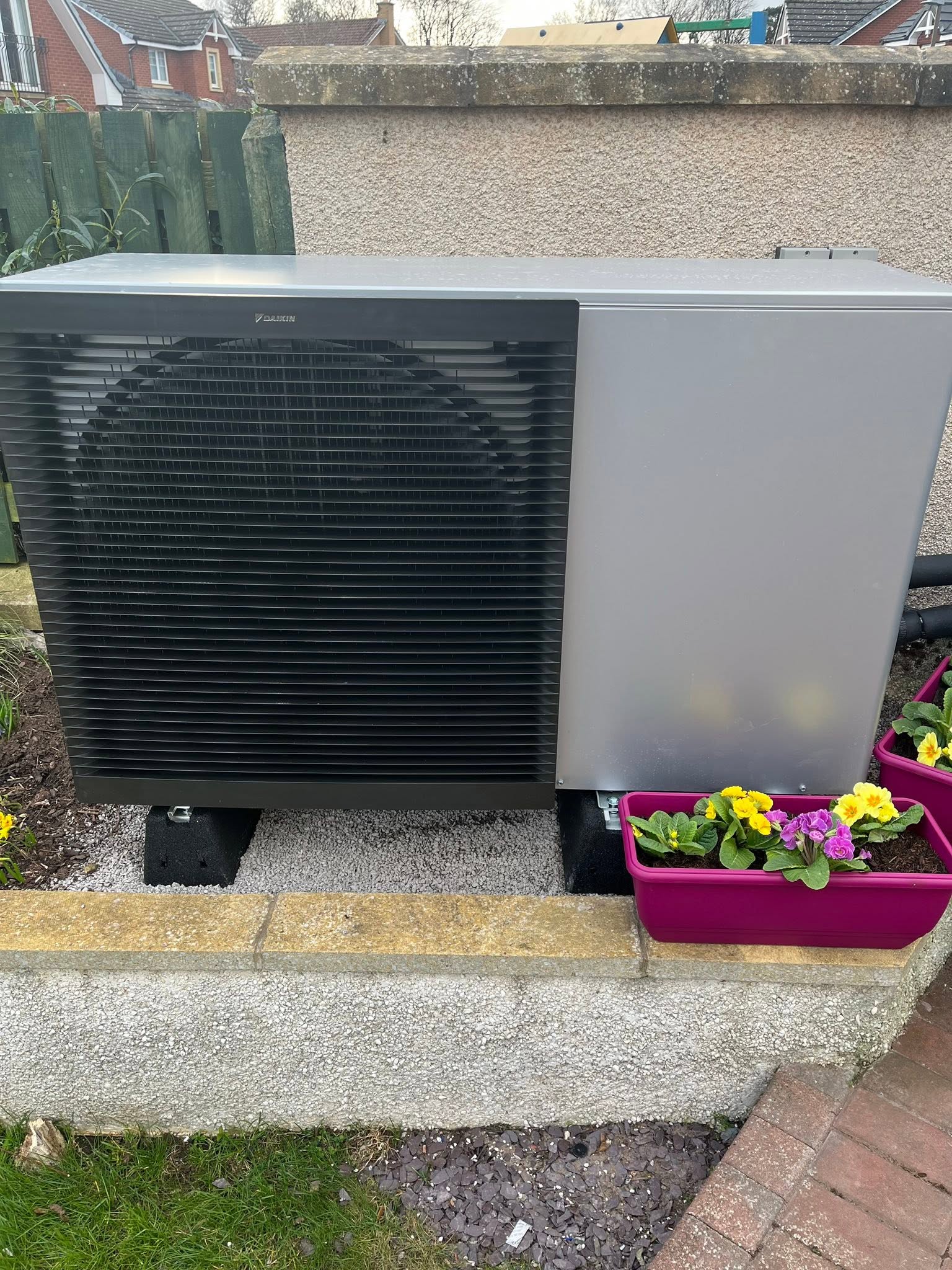 FLO heat-pump outdoor unit installed in a residential garden